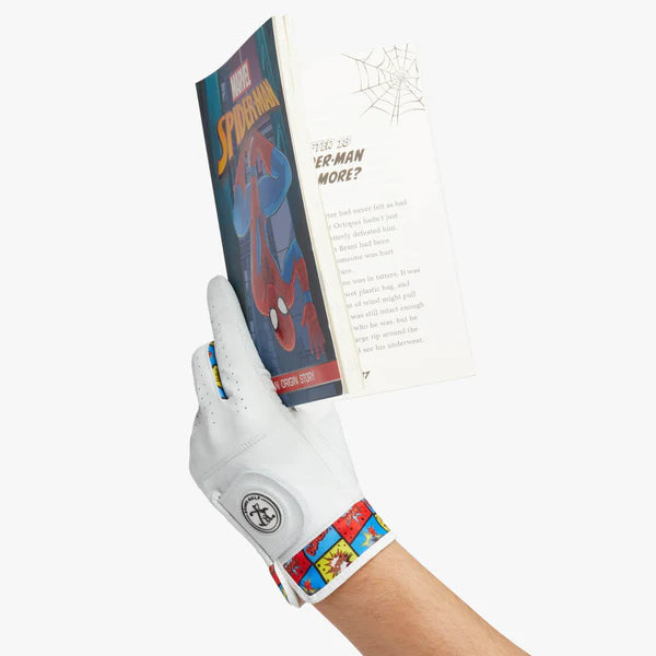 En arm med en golfhandske med serieteckning mönster på, handen håller i en Spindelmannen bok